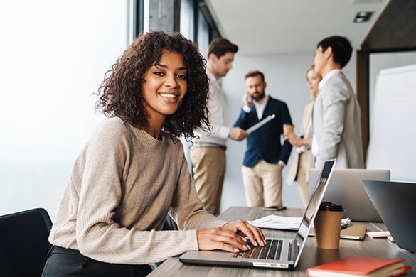 A corporate employee types at a laptop